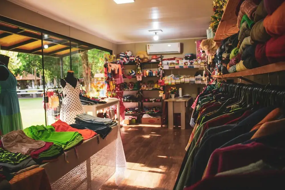 Araras de roupas e prateleiras de artigos dentro da loja