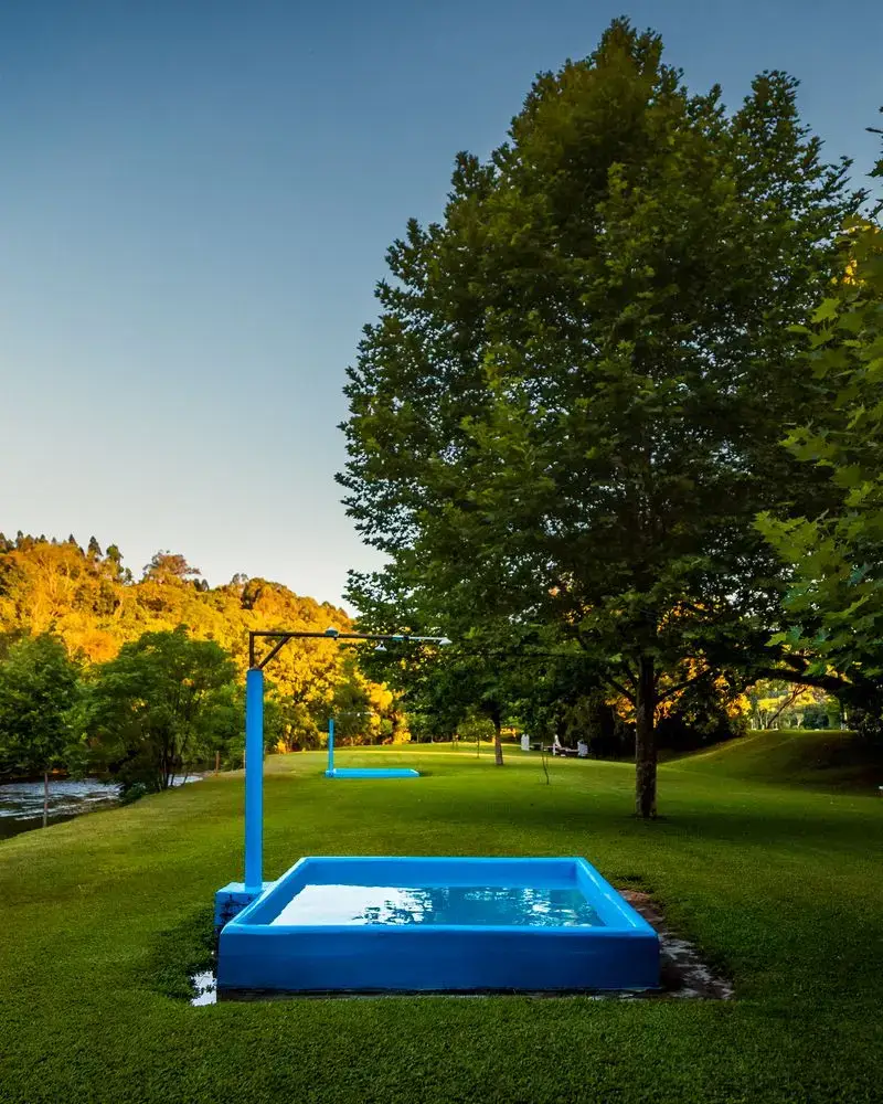 Piscina infantil rasa, azul, com chuveiro, no gramado